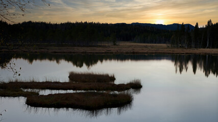 Sunrise over the lake. The sky is dramatic and on fire. Shot in Nordmarka, Oslo, Norway. 
