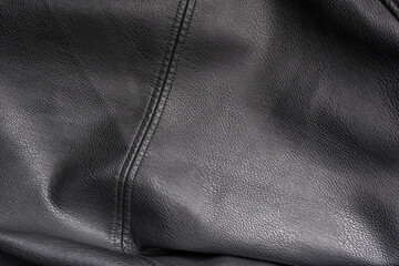 Closeup of black heavy leather material with a seam in the middle, deep texture, highlights and shade for design, texture background and displacement maps, with large canvas and copy space