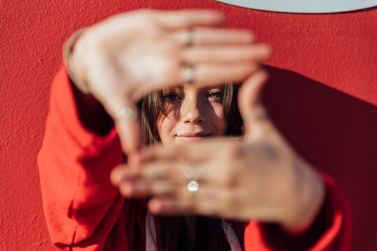 Teenage girl making frame with hands