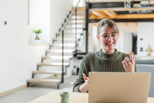 Businesswoman gesturing during video call on laptop at home
