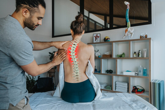Physiotherapist treating female patient's bent spine