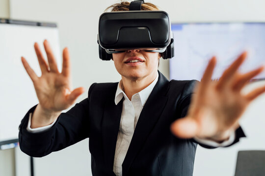 Businesswoman gesturing while wearing virtual reality simulator in office