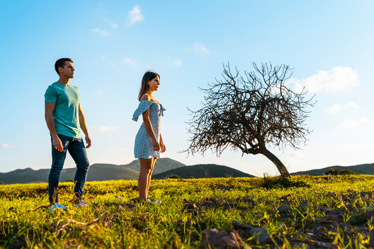 Young woman standing at distant with man on grass