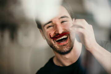 Cheerful man holding red chilli, imitating mustache
