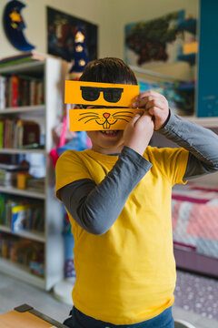 Playful boy with emoticons at home