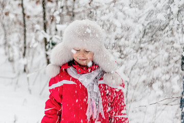 Portrait of a girl standing in a wintry forest
