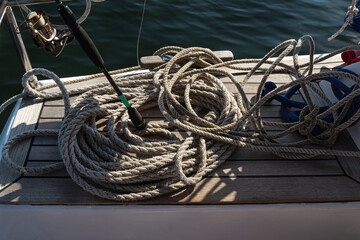 cables and twine on deck of the boat. Sailboat on water surface in calm