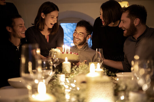 Men and women celebrating birthday of male friend at home