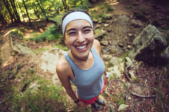Smiling woman wearing headband standing in forest