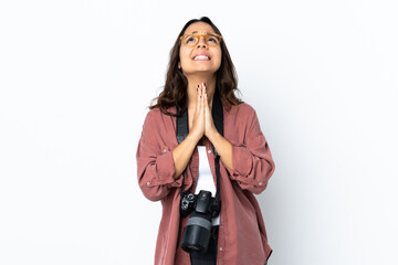 Young photographer woman over isolated white background keeps palm together. Person asks for something