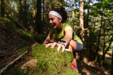 Active female athlete climbing rock in forest