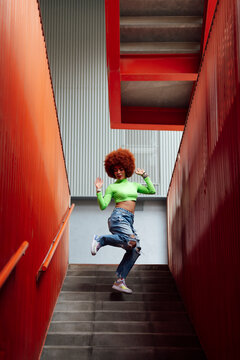 Cheerful woman dancing on staircase