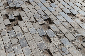 Old damaged cobbled road, concrete street pavement