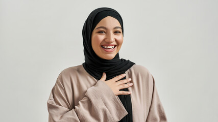 Portrait of laughing young arabic woman in hijab - obrazy, fototapety, plakaty