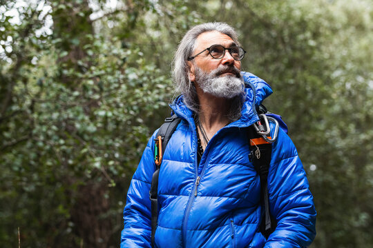 Senior man with gray hair looking away in forest
