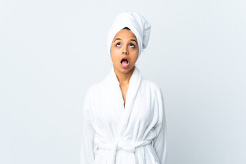 Young woman in bathrobe over isolated white background looking up and with surprised expression