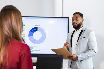 Young male entrepreneur planning business plan with colleague in office