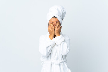Young woman in bathrobe over isolated white background covering eyes by hands