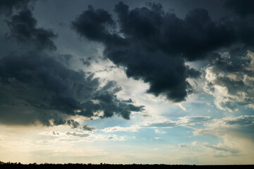 beautiful dark dramatic sky with sunlight and clouds as a background