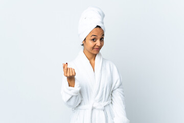 Young woman in bathrobe over isolated white background making money gesture