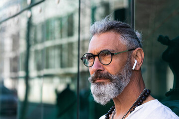 Hipster man with in-ear headphones looking away