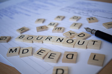 Auf Papier gelegtes Wort Bournout neben Füller