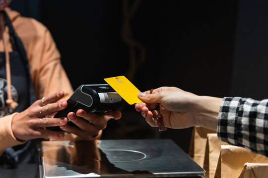 Female customer giving credit card to owner at supermarket
