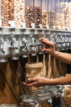 Woman buying nuts in jar at supermarket