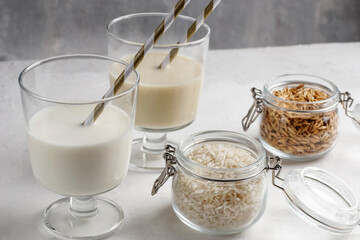 Natural breakfast. In glass glasses, gluten-free rice and buckwheat milk on a light background. Organic vegetarian drinks. Health concept.