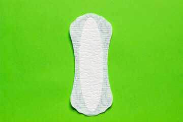 Feminine hygiene panty liner for menstruation. Menstrual cycle, pad. green background.