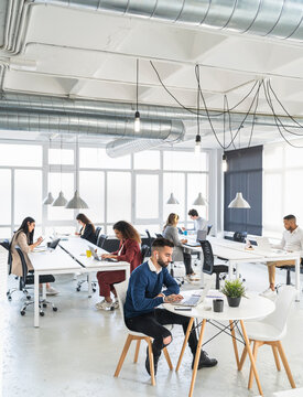 Male and female professionals working on laptop at coworking office