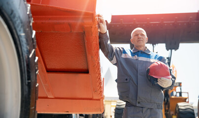 Driver man of construction equipment excavator or tractor. Builder or mining industrial work