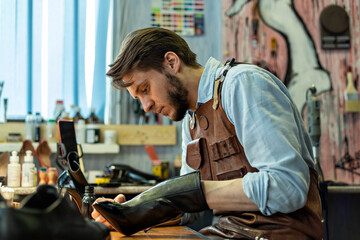 Male craftsperson repairing shoe at workshop