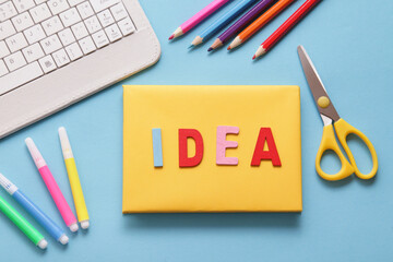 White Keyboard, colorful word IDEA, colorful stationery on blue background. Copy space. Online courses. remote e-learning class. Art education concept.