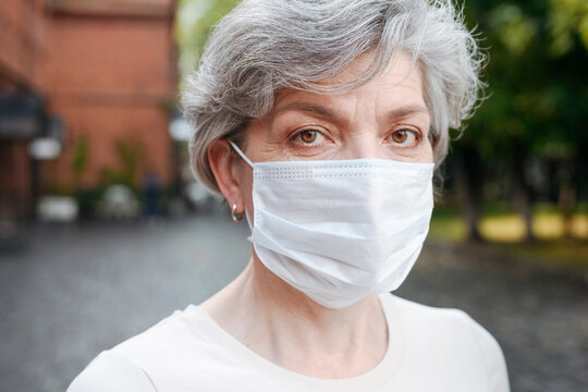 Mature woman with protective face mask during pandemic