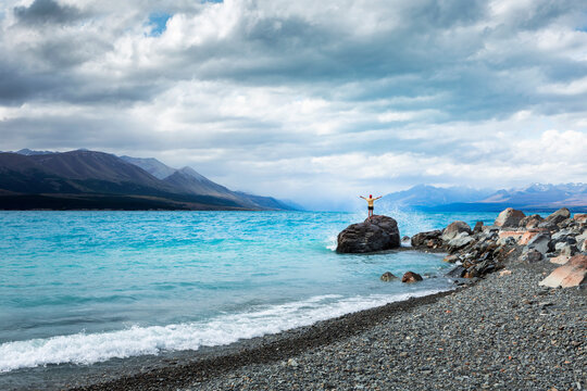 New Zealand, Canterbury, Young man enjoying stony beach at Lake Tekapo
