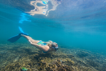 Underwater view of young woman diving in Java Sea