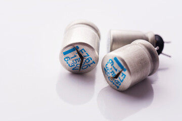 Damaged cracked electrolytic bloated exploded capacitors isolated on white background. Minimal...