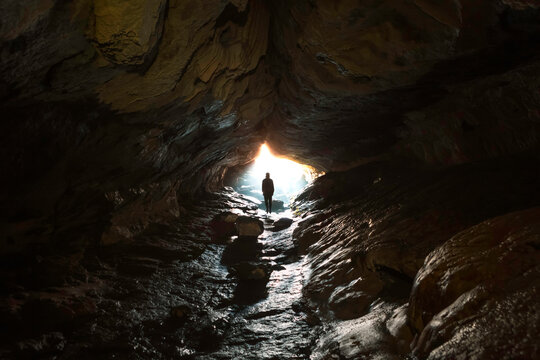 New Zealand, South Island, Fiordland National Park, Man at entrance of cave