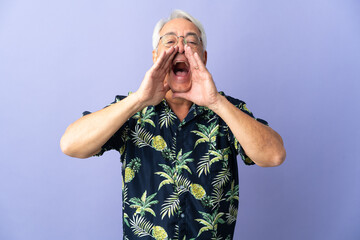Middle age Brazilian man isolated on purple background shouting and announcing something