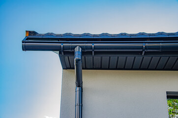 Gutter with downpipe on the roof of a house.