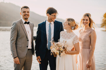Smiling bride and groom with guests during wedding ceremony