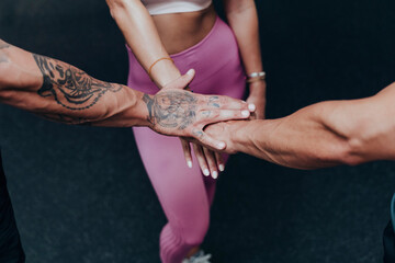 Sportswoman hand stacked with friends in gym