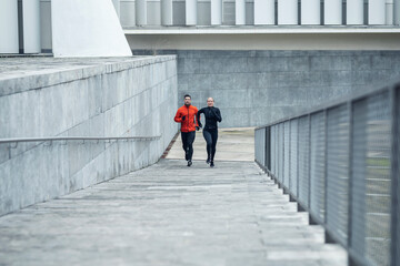 Male and female athletes running up on slope