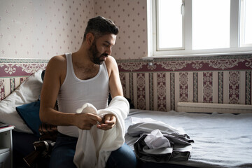 Businessman in vest getting dressed while sitting at home