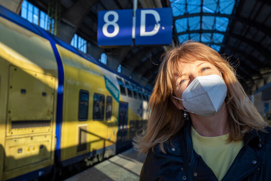 Mature woman wearing protective face mask at railway station during pandemic