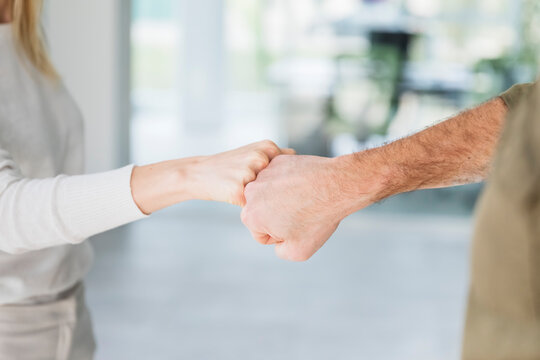 Male and female entrepreneurs dong fist bumps at office