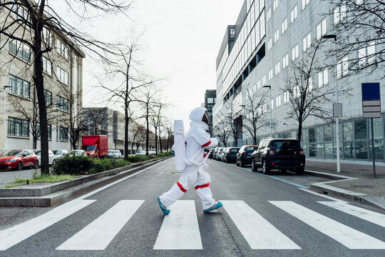 Female astronaut crossing road in city