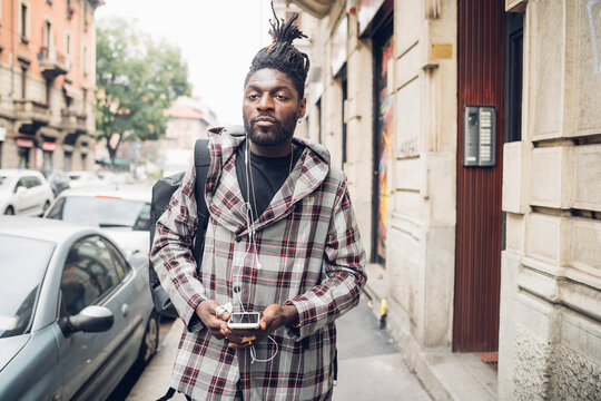 Young man with mobile phone in city