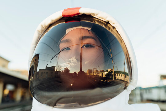 Female astronaut wearing helmet during sunset
